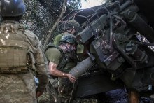 Ukrajinskí vojaci nabíjajú granát do húfnice neďaleko frontového mesta Kramatorsk v Doneckej oblasti. FOTO: Reuters